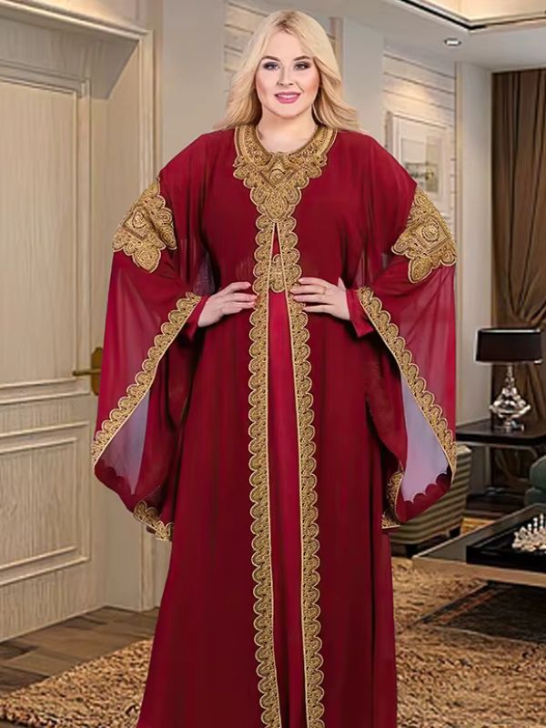 Une femme porte un caftan en ayant les mains sur les hanches