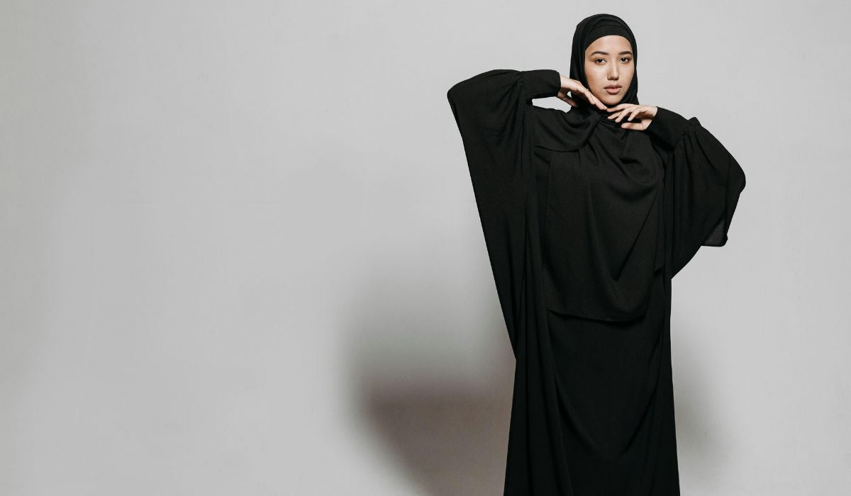 Femme vêtue d'une abaya noire ample, silhouette traditionnelle des Émirats