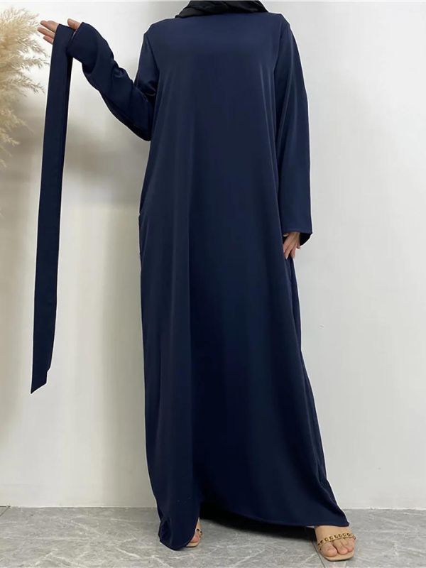 Une femme porte une abaya bleu marine fluide et ample