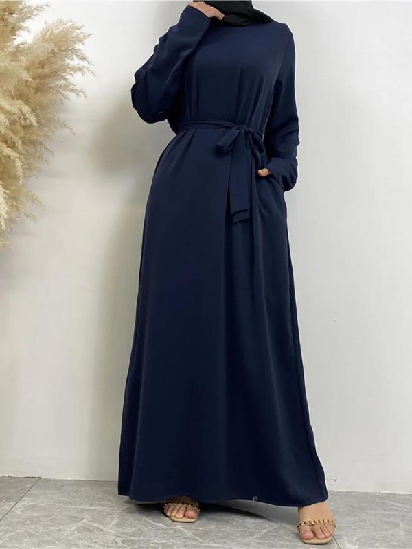 Une femme porte une abaya bleu marine fluide et ample