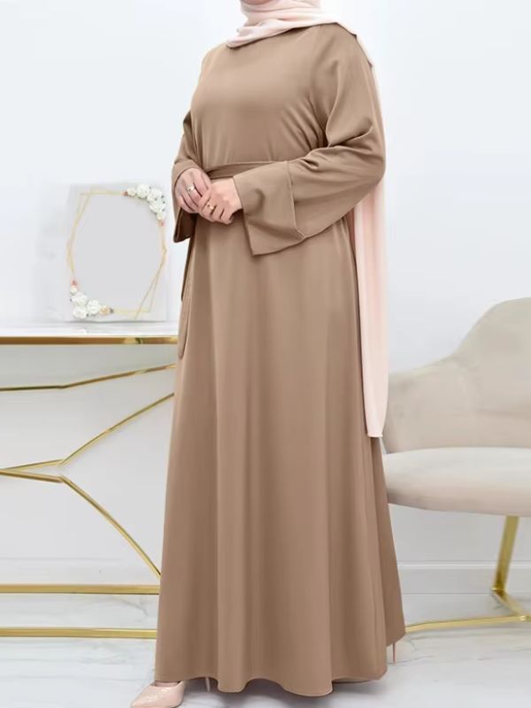 Une femme porte une abaya beige sable et se prends en photo