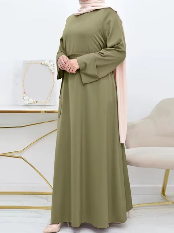 Une femme porte une abaya vert olive