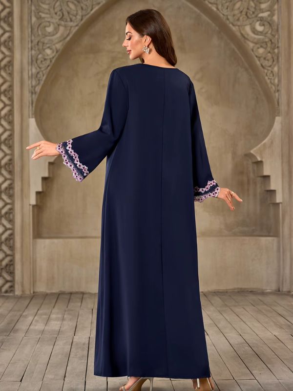 Abaya Dubaï bleu marine, vue de dos, robe unie avec couture centrale et manches évasées bordées de dentelle florale