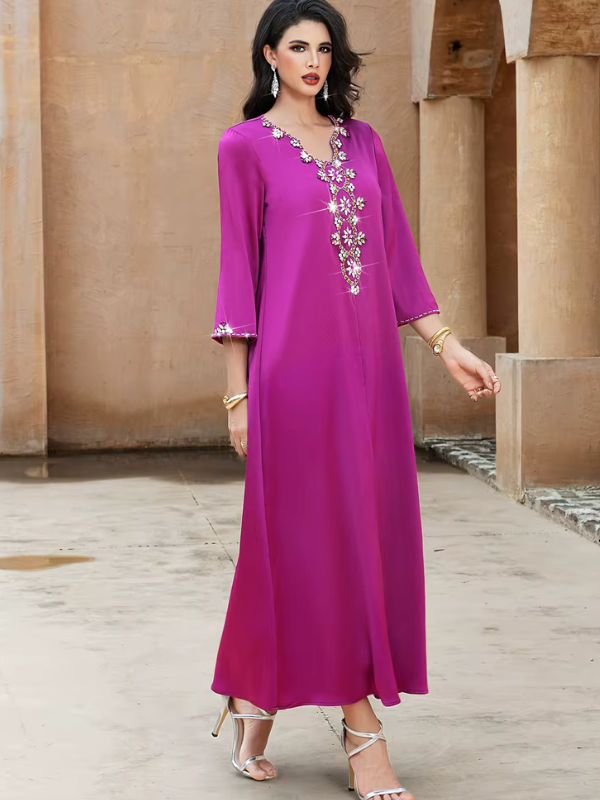 Abaya Dubaï fuchsia, vue de face en pied, col en V orné de fleurs de strass, manches trois quarts évasées et robe évasée jusqu'aux chevilles