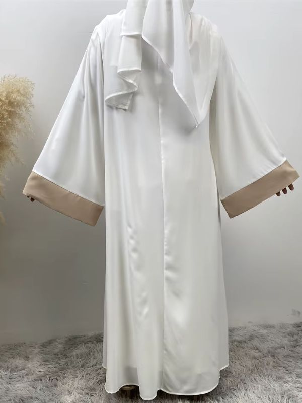Femme qui porte une abaya beige et blanche et de dos