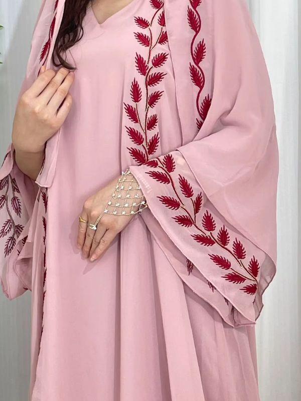 Une femme porte une abaya dubai rose blush