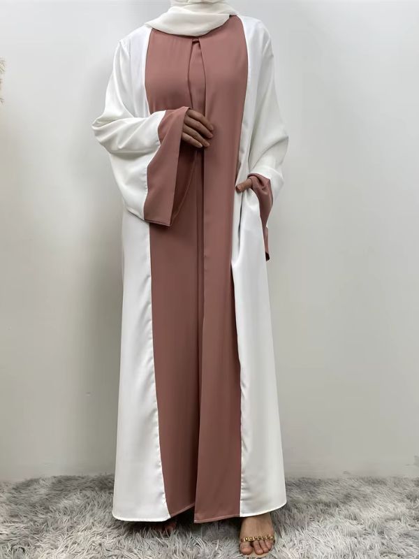 Une femme porte une abaya rose poudré et blanche