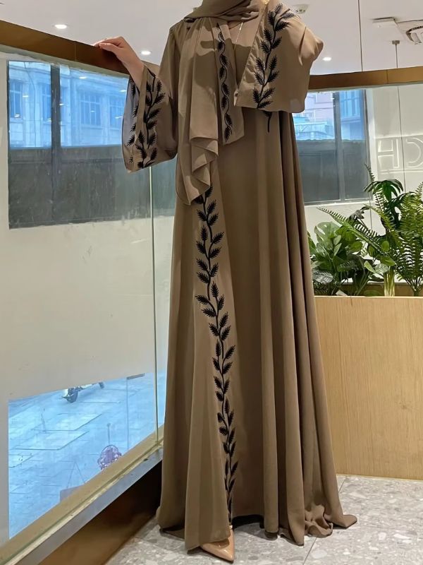 Une femme se cache le visage tout en portant une abaya dubai kimono