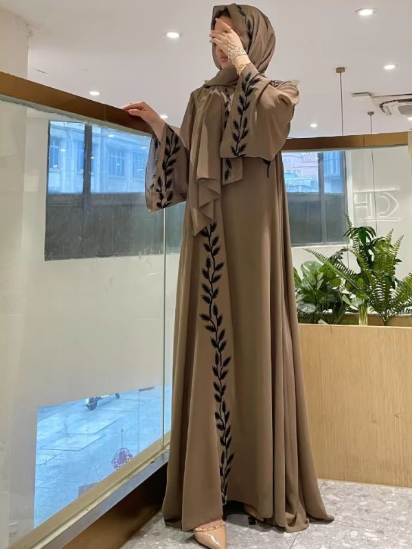 Une femme se cache le visage tout en portant une abaya dubai kimono