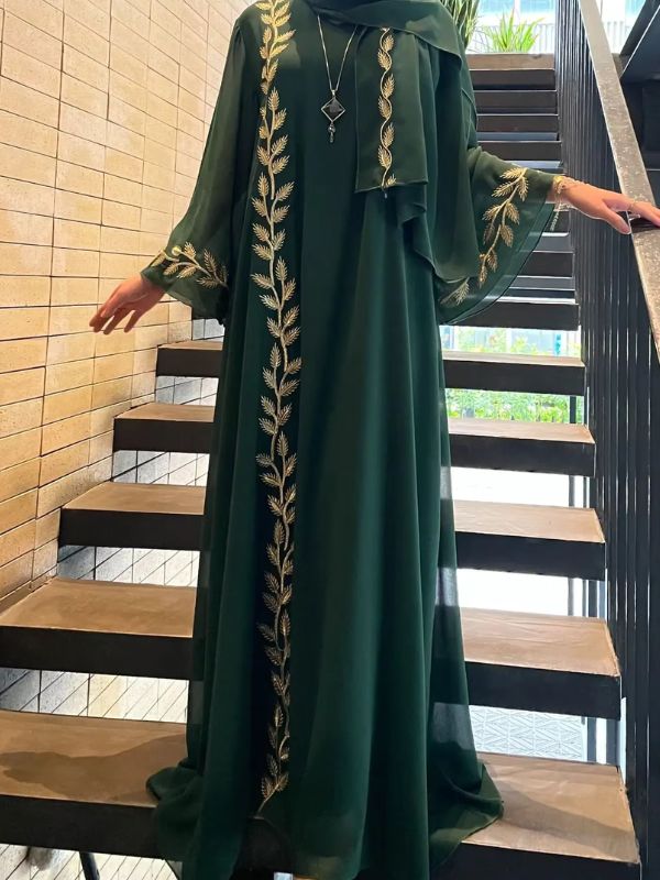 Une femme porte une abaya dubai kimono emeraude