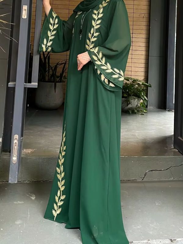 Une femme porte une abaya dubai kimono emeraude