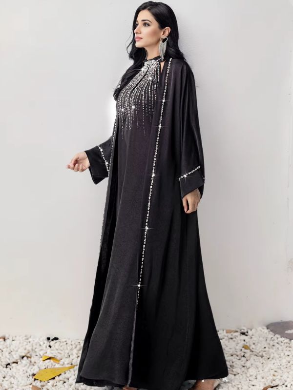 Femme de profil en abaya noire décorée de strass scintillants