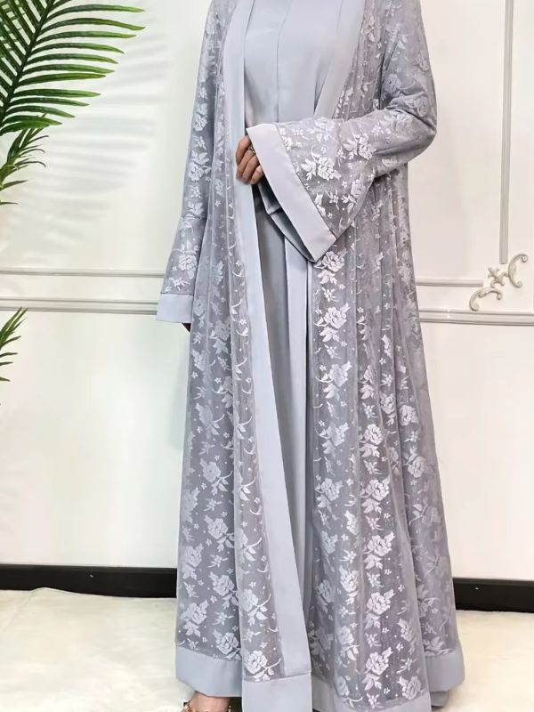 Une femme porte une abaya en dentelle gris perle