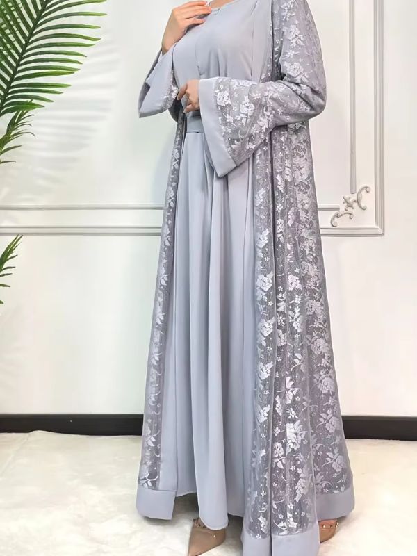 Une femme porte une abaya en dentelle gris perle