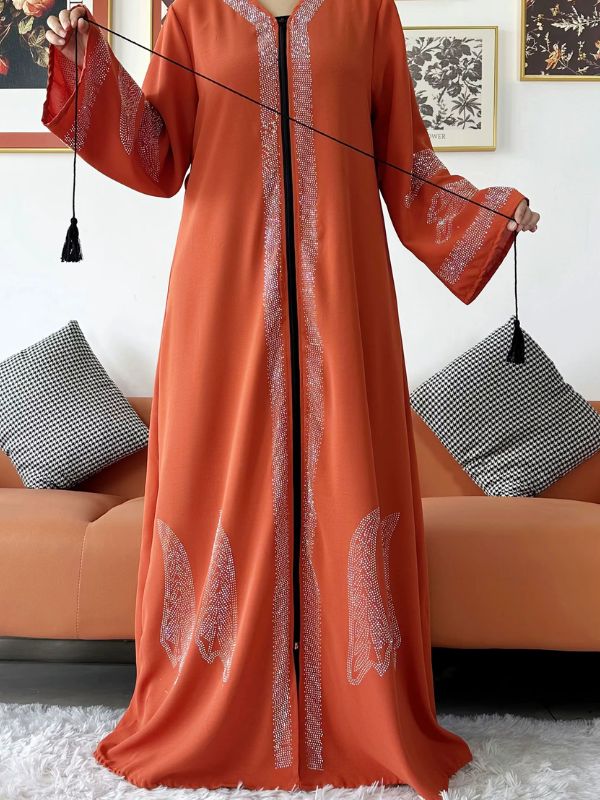Une femme porte une abaya dubai de couleur orange