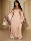 Une femme porte une abaya longue en satin beige doré avec dégradé brun sur les manches, posant de face avec un sac perlé