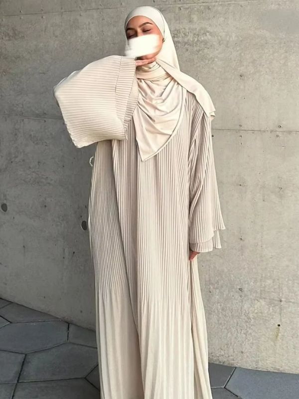 Une femme en abaya robe longue beige