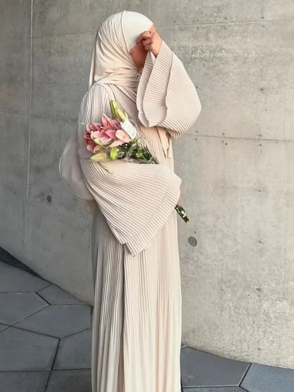 Une femme en abaya robe longue beige