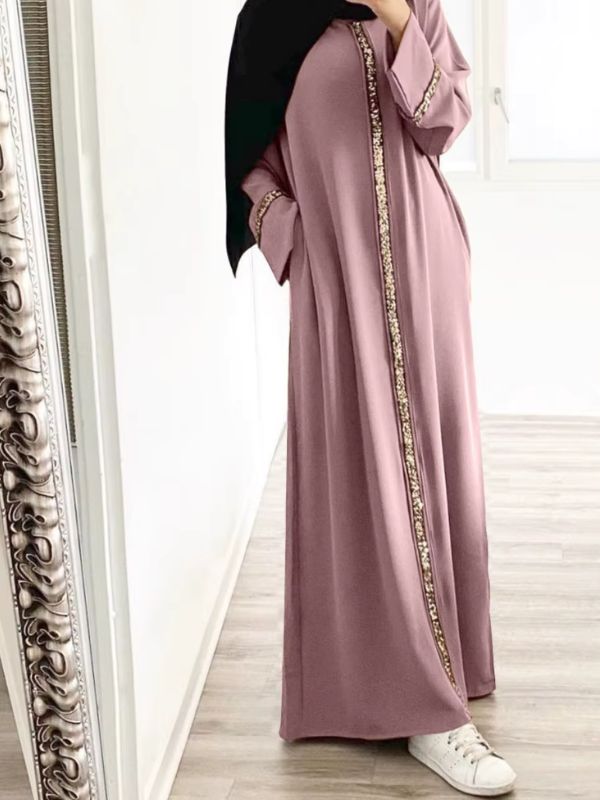 Une femme porte une abaya rose figue avec broderies dorées
