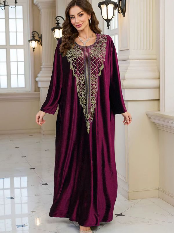 Abaya Dubaï en velours bordeaux, vue de face en marchant, plis souples du velours et manches longues évasées