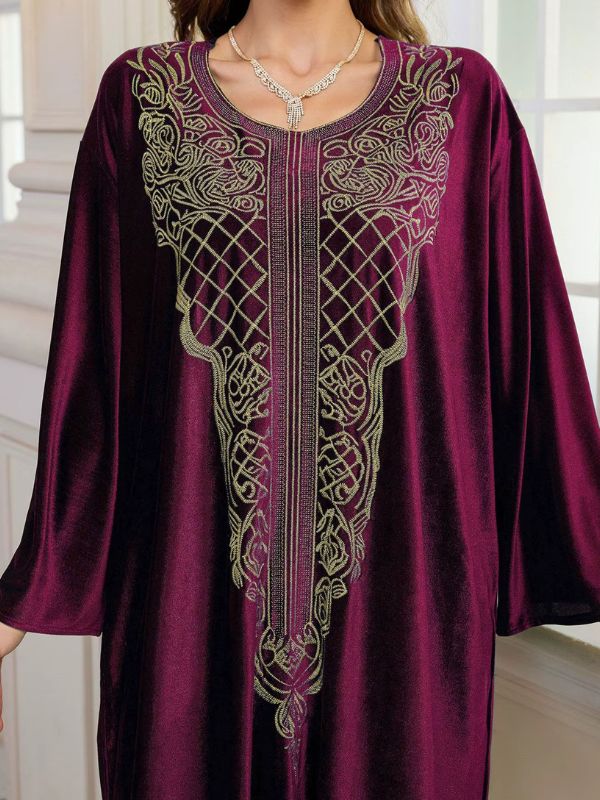 Abaya Dubaï en velours bordeaux, gros plan sur le plastron brodé de fils dorés : treillis de losanges, volutes et bande centrale de fines lignes