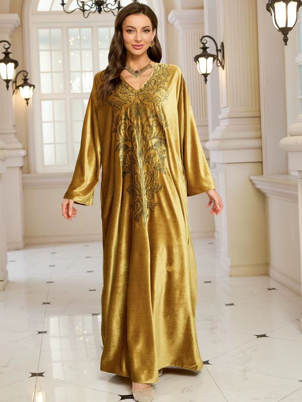 Abaya Dubaï en velours moutarde, vue de face, bras le long du corps, robe ample jusqu'au sol et col en V