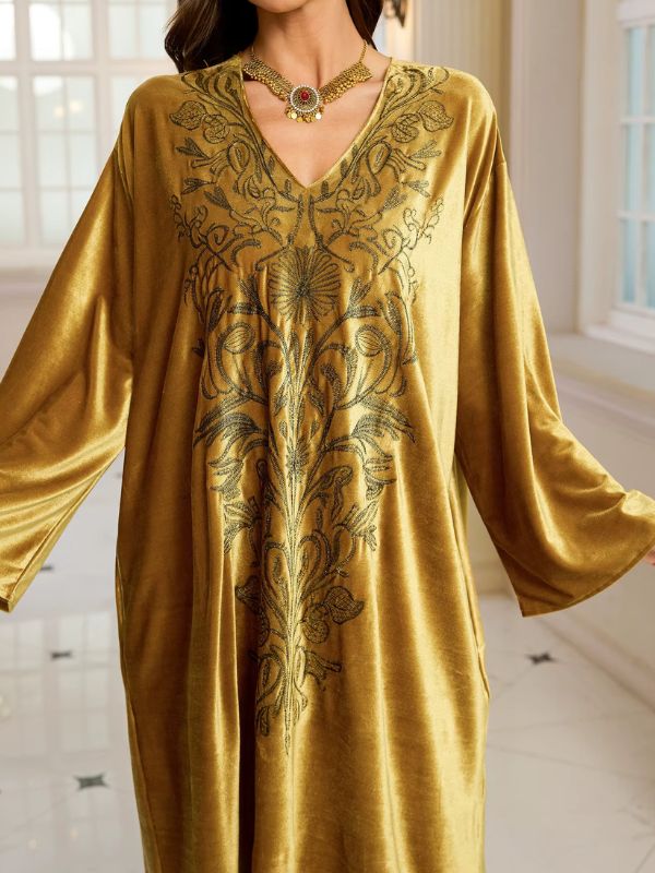 Abaya Dubaï en velours moutarde, gros plan sur le col en V et la broderie florale : rosace centrale, tiges, feuilles et vrilles
