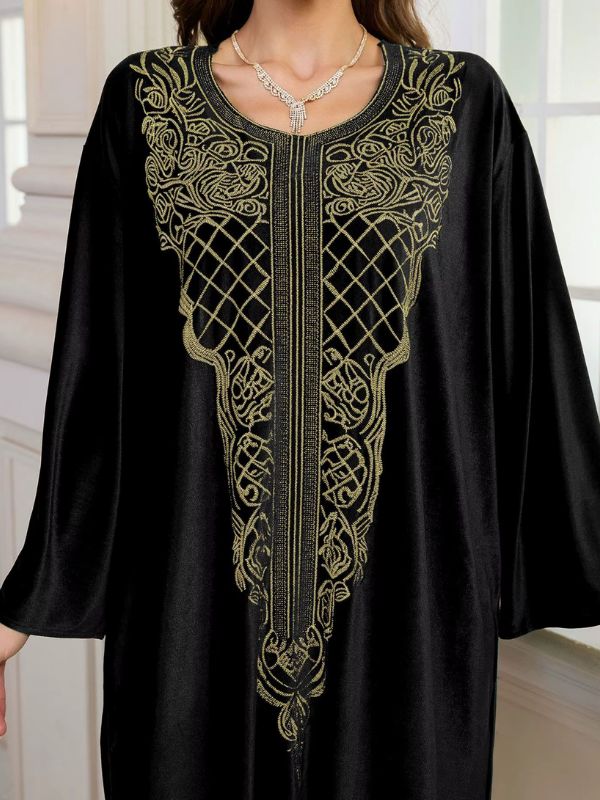 Abaya Dubaï en velours noir, gros plan sur le plastron brodé de fils dorés : treillis de losanges, volutes et bande centrale de fines lignes
