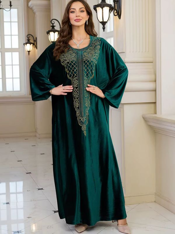 Abaya Dubaï en velours vert bouteille, vue de face, bras écartés montrant l'ampleur des manches et le plastron brodé doré