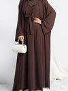 Une femme porte une abaya marron