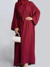 Une femme porte une abaya deux pièces de couleur rouge