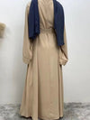 Femme qui se trouve de dos et porte une abaya kimono beige 