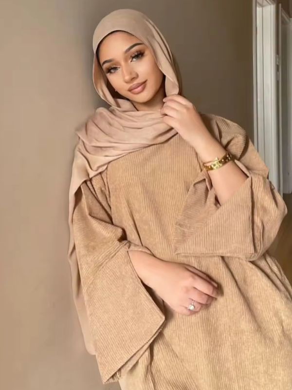 Une femme porte une abaya de couleur beige