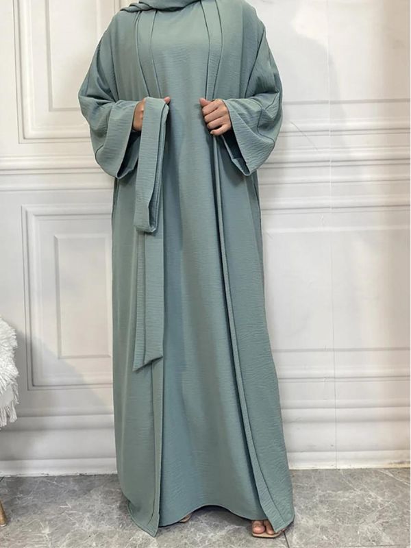 Une femme tient la ceinture de son abaya kimono dubaï azur