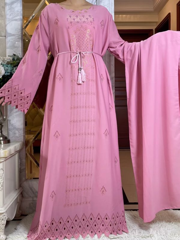 Une femme porte une abaya kimono dubai rose poudre satiné