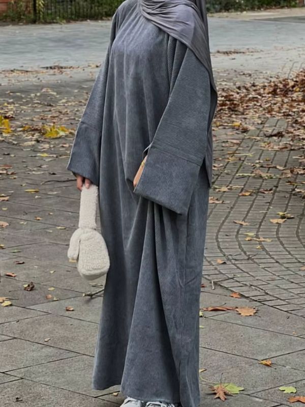 Une femme porte une abaya grise