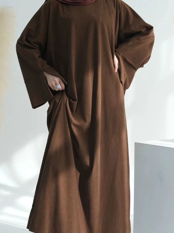 Une femme musulmane porte une abaya kimono marron