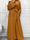 Une femme montre sa magnifique robe abaya kimono couleur ocre