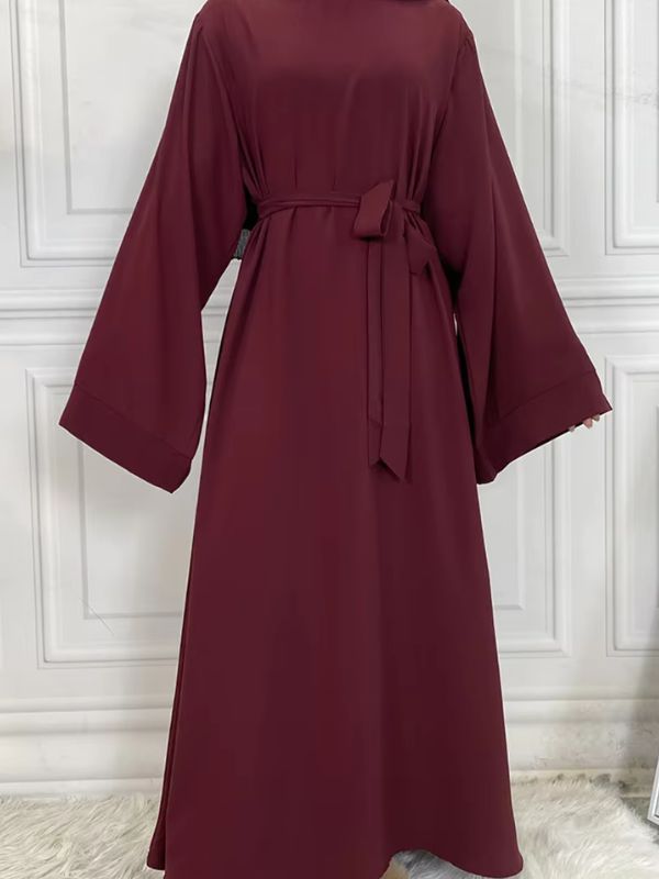 Une femme qui porte une abaya kimono rouge grenat large avec des longues manches