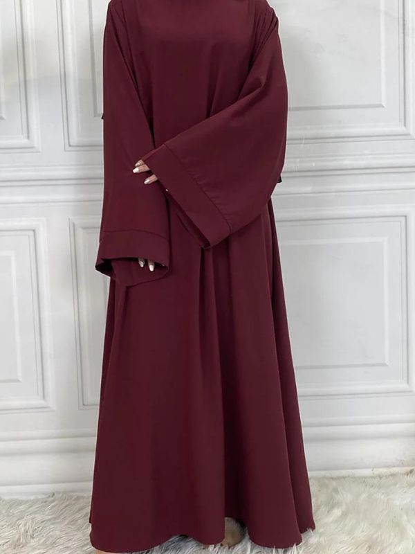 Une femme qui porte une abaya kimono rouge grenat large avec des longues manches