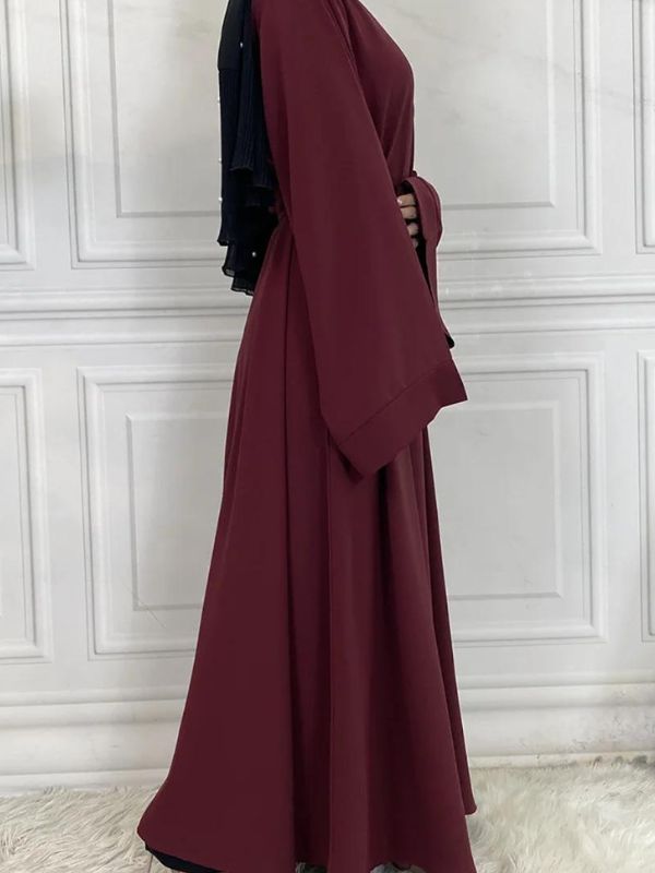 Vue latérale d&#39;une abaya kimono rouge grenat avec manches longues et coupe fluide