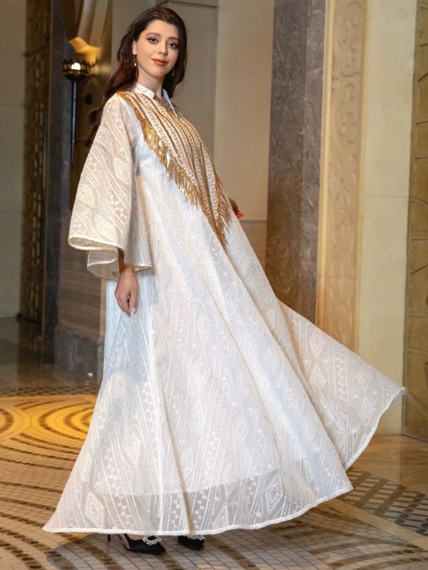 Une femme se tient de profil et porte une abaya de mariage