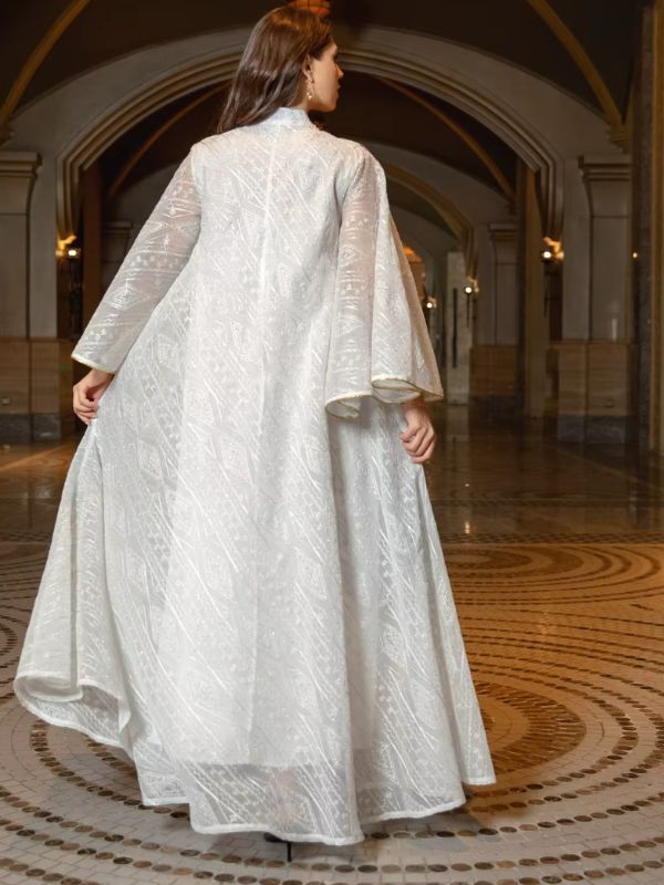 Une femme se tient de dos et porte une abaya blanche