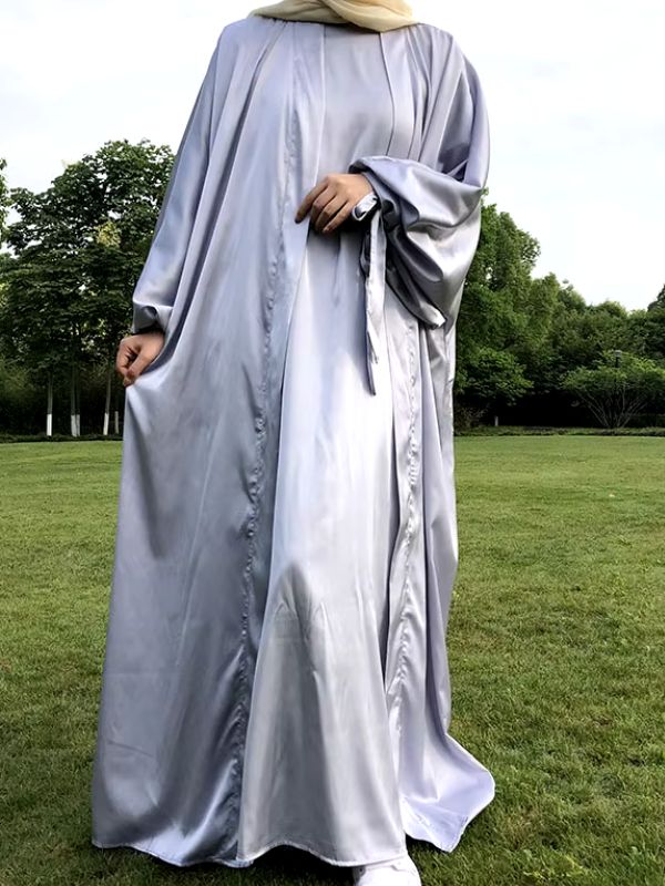 Jeune femme en abaya papillon de couleur argentée