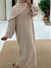 Une femme en abaya velours de couleur beige