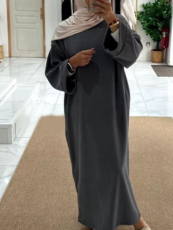 Une femme en abaya velours grise