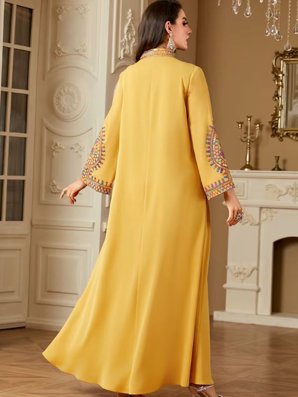 Une femme de dos porte une abaya de couleur jaune