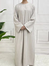 Une femme en abaya de satin blanc