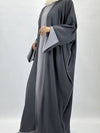 Une femme porte une abaya kimono ouverte de couleur gris foncé