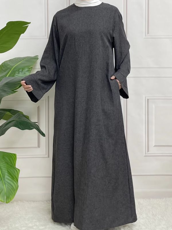 Une femme porte une abaya en satin gris